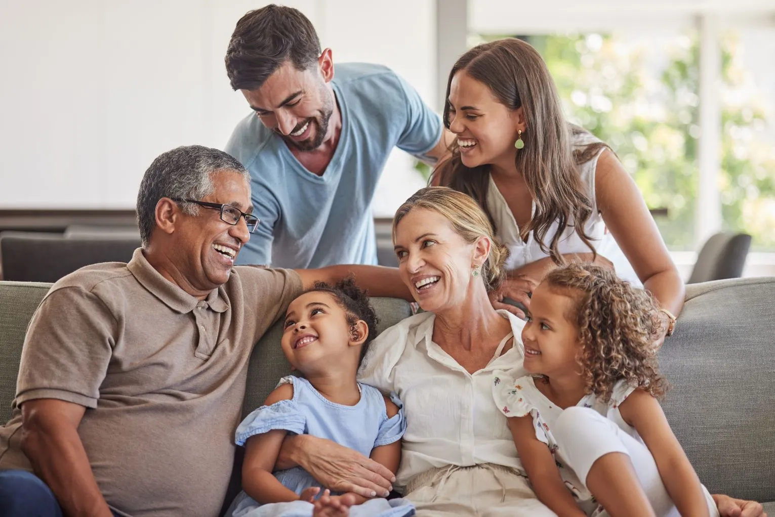 A happy family gathered on a couch, sharing a moment of togetherness and laughter in their living room.
